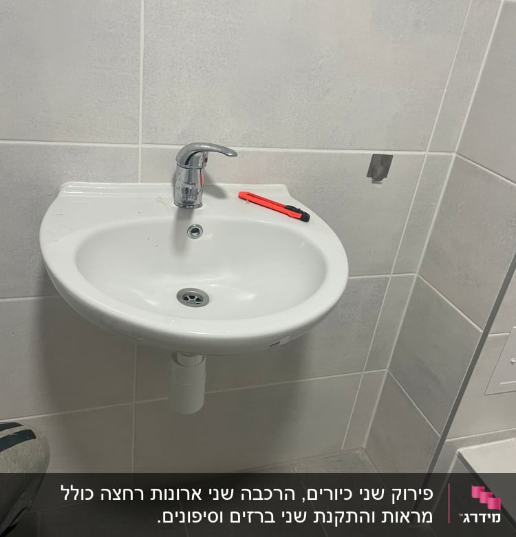 כיור עם ברז וסכין יפנית על השיש